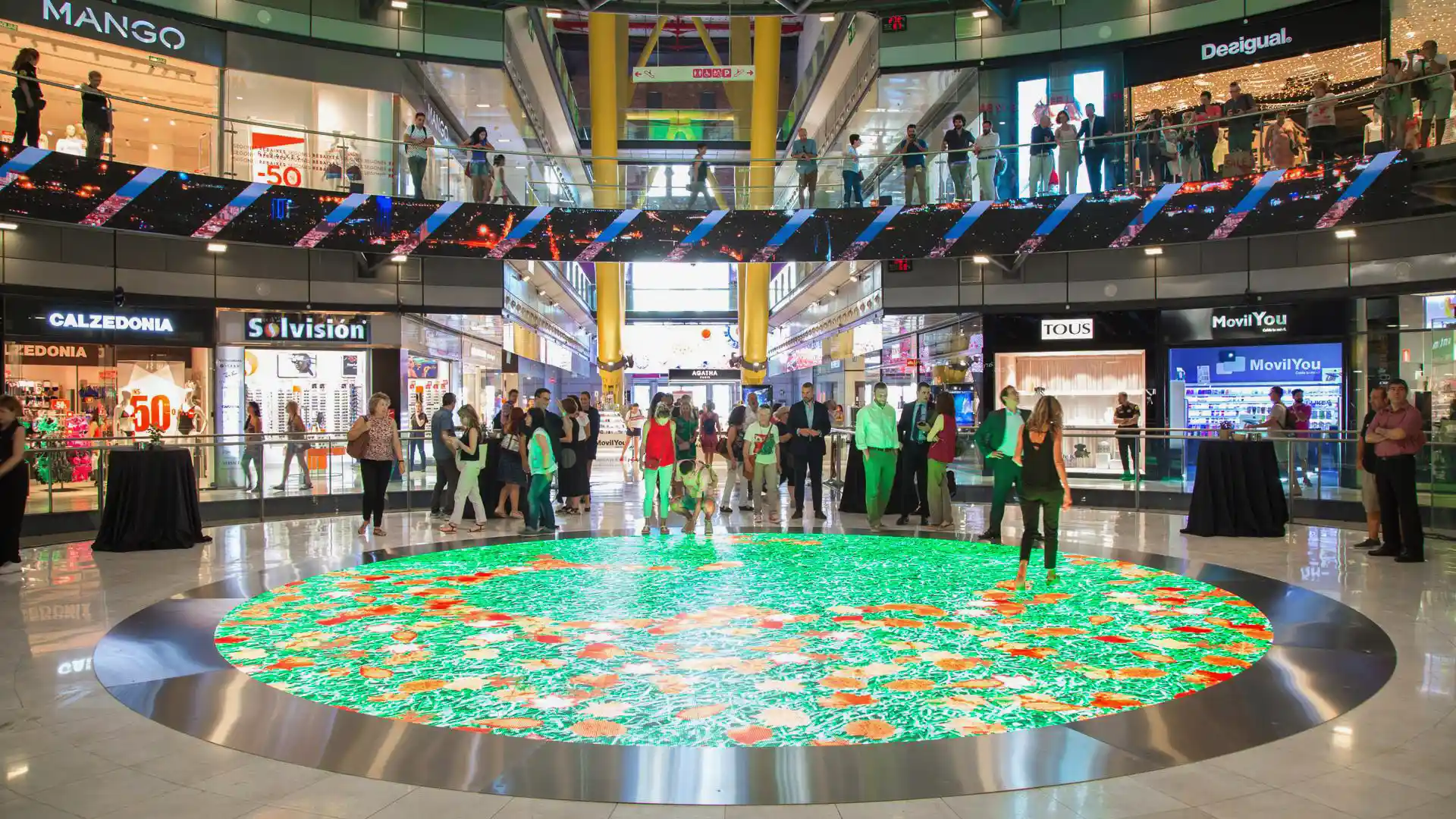 Interactive circular LED floor synchronised with suspended LED ring inside Arenas de Barcelona.