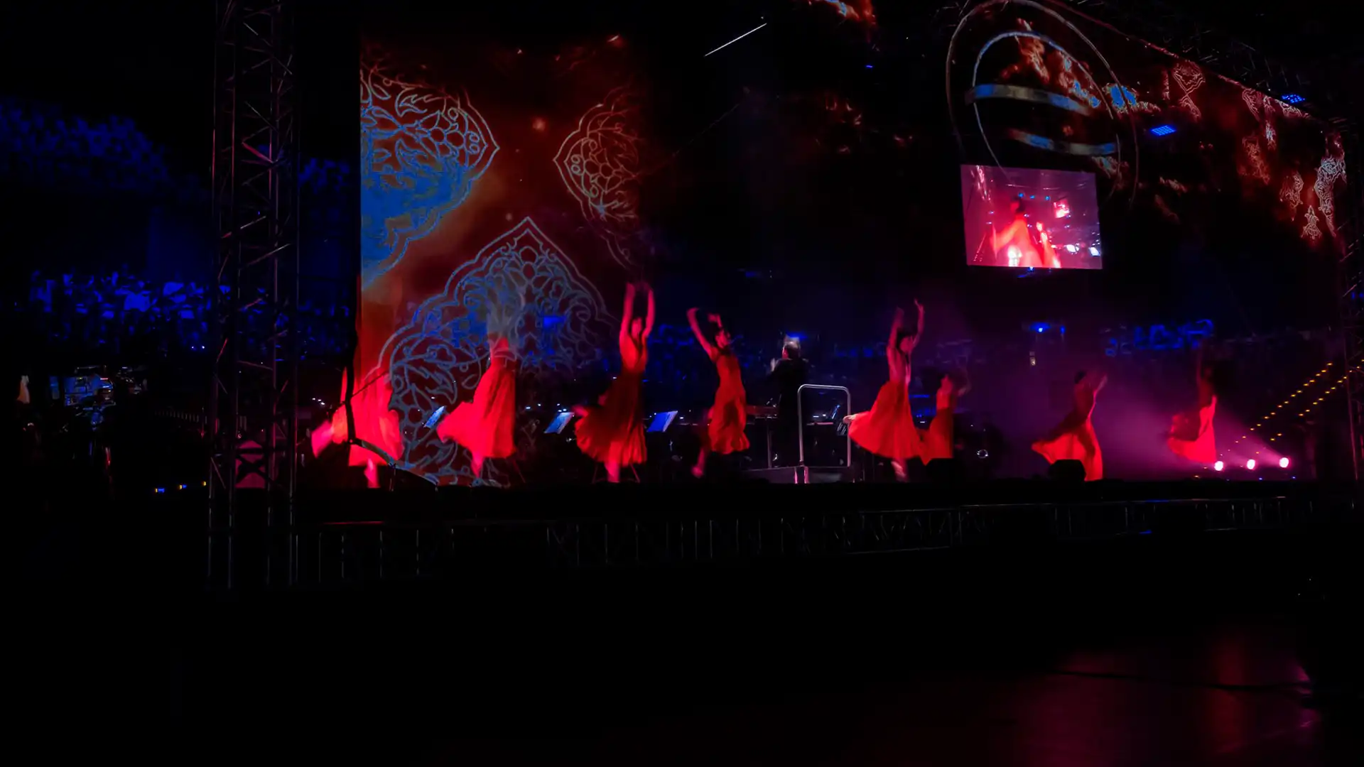 Stage performance with dancers and red lighting during live audiovisual show