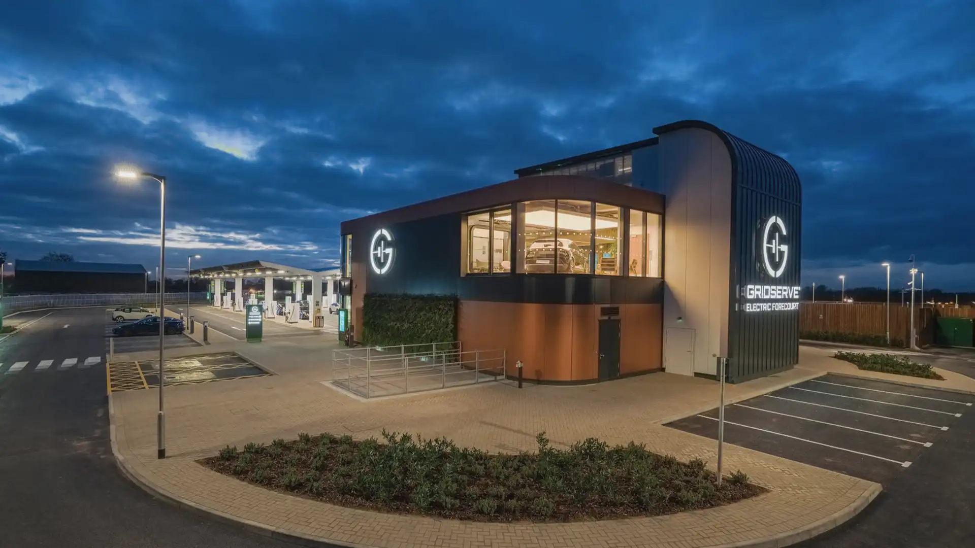 Exterior view of GRIDSERVE’s Electric Forecourt® in Braintree, featuring digital signage and architectural LED displays integrated into the station’s sustainable design.