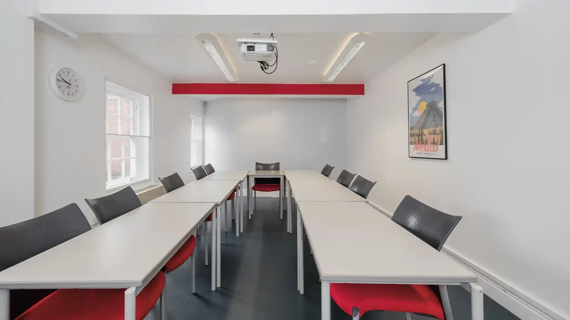 Configuración audiovisual estandarizada de aulas en el Instituto Cervantes, con pantallas integradas y tecnología docente.