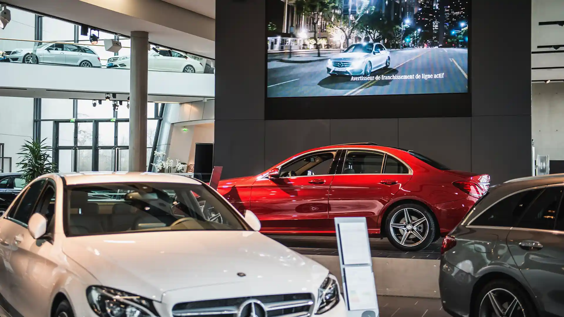 Paris Mercedes-Benz showroom featuring large LED screen showcasing premium brand content by TRISON.
