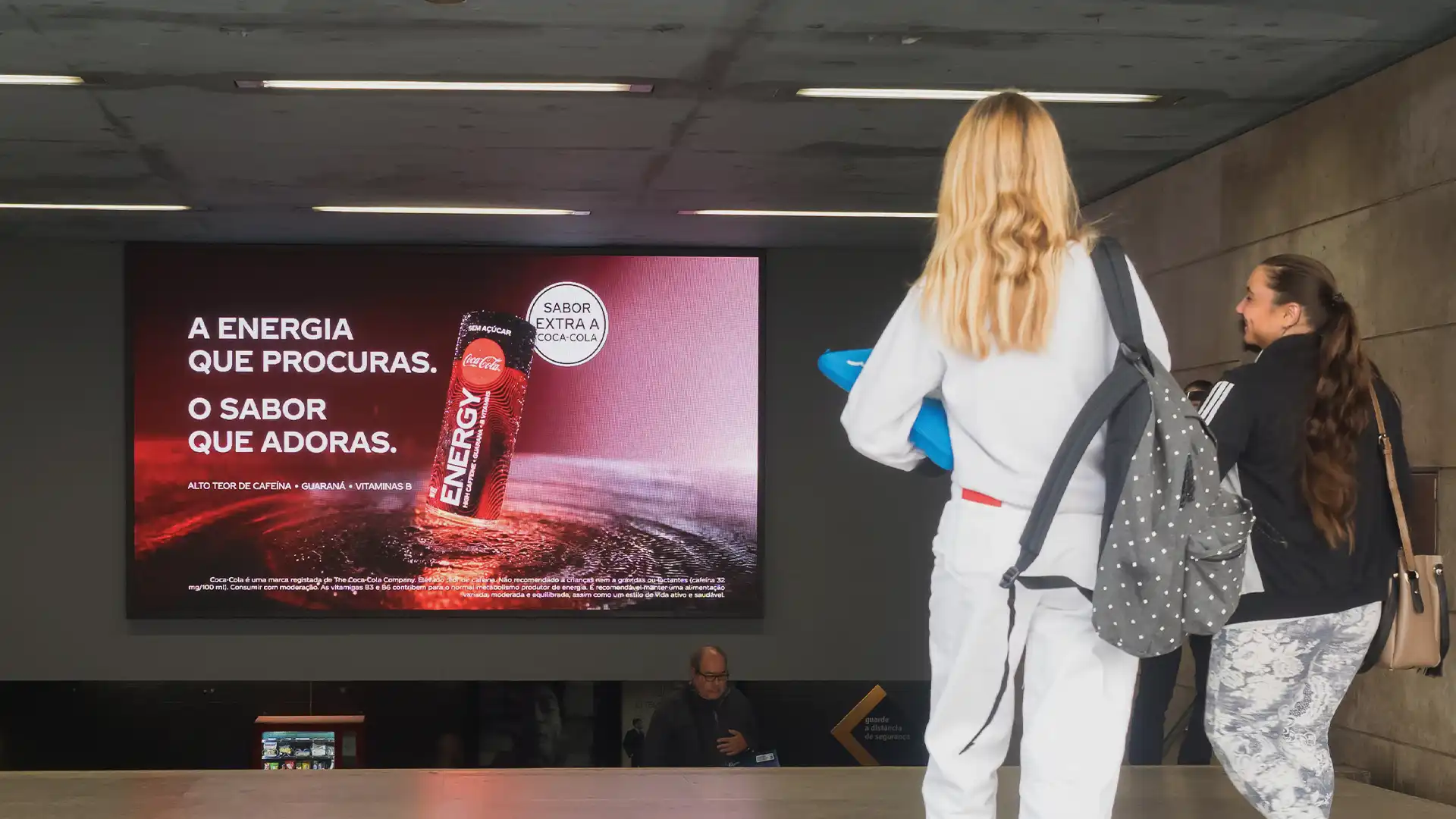 Viajeros viendo contenidos dinámicos en pantallas digitales en la estación de metro de Lisboa modernizada por TRISON.