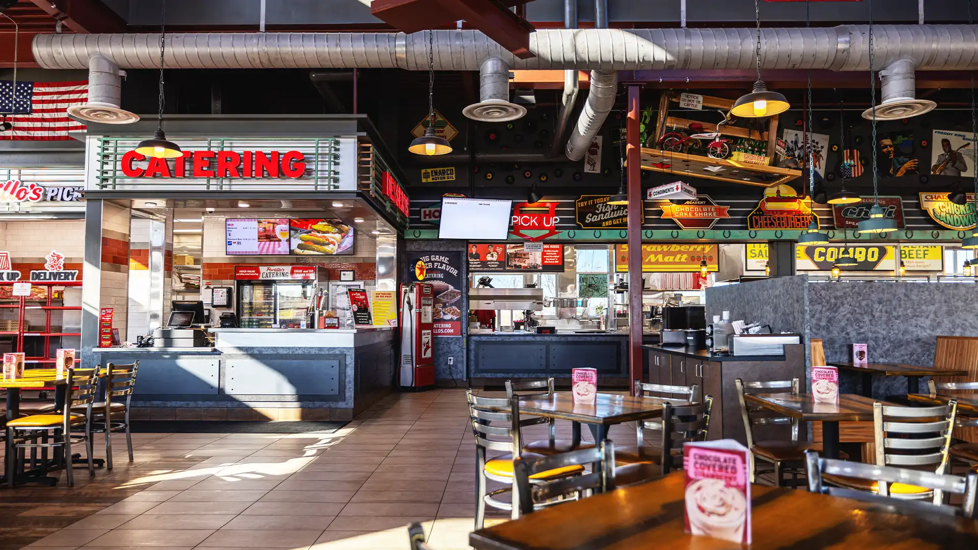 Pantalla digital en el restaurante Portillo's que muestra la narración de la marca y contenidos promocionales coherentes con la identidad corporativa.